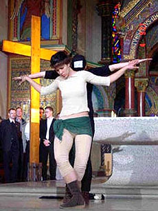 Женщина имитирует Христа, мужчина сзади нее – распятие вблизи алтаря базилики св. Иоанна в Берлине. В зале присутствовали католические кардиналы, 2004 г.