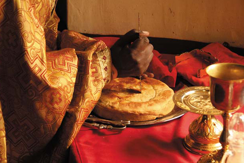 Проскомидия. Из большой просфоры вырезаются частицы. Одна из них — за всех православных христиан во всем мире, включая Россию