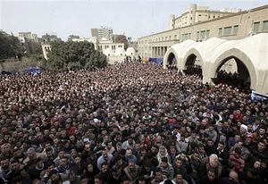 Собравшиеся у собора святого Марка смотрят на большие экраны, на которые трансируются траурная служба. 