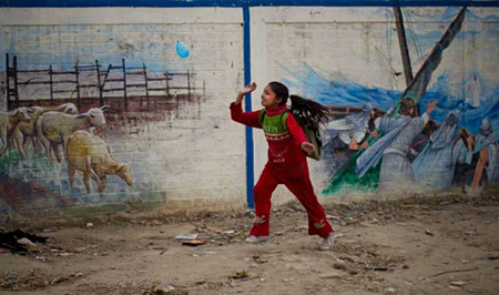 In photo taken Sunday, March 11, 2012 A Pakistani Christian girl plays with a balloon next to a wall with biblical paintings at the Christian colony in the center of Islamabad, Pakistan. Roughly five percent of Pakistan's 180 million people belong to minority religions, which include Hindu, Christian, Shiite Muslims and Ahmedis, according to the CIA World Factbook. (Anja Niedringhaus / AP)