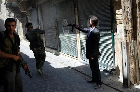Members of the Free Syrian Army (FSA) shoot at a nearby government army position in the al-Jadeida neighborhood, in the Old City of Aleppo, on August 21, 2012. The FSA has pushed into al-Jadeida, which houses a minority of Christians in the predominantly Muslim city. (AFP PHOTO/PHIL MOORE)