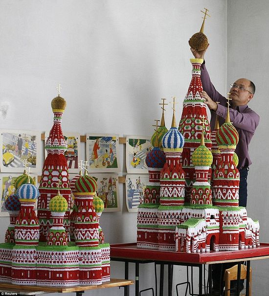 Remarkable: Sergei Tarasov, 42, puts the finishing touches to his incredible modular origami model of Saint Basil's Cathedral at his home in Tigritskoye.