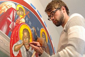 Since furthering his study in iconography this summer in Greece, Syracuse artist Brian Whirledge recently completed the largest icon painting he has made to date, measuring 6-feet wide and 4-feet tall. Taking about 45 hours to get to this point, the icon, which was painted on canvas, will be affixed to a wall inside the nave of his home church, St. Mary’s Orthodox Church in Goshen, by Christmas. Christian icons as an art form date back more than 1,700 years. (Photo by Rebekah Whirledge)