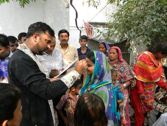 Fr. Adrian chrismating Orthodox Pakistanis. Photo from the church's facebook cite.