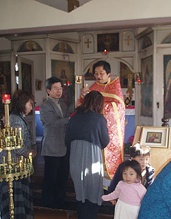  Причащение трехлетней Софии, пятилетнего Леандра и их мамы Нины Огата за Рождественской литургией в Хитоёси