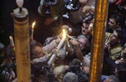 Иерусалимский Патриарх Ириней передает Благодатный огонь верующим, 2002 г. (AP Photo/Elizabeth Dalziel)
