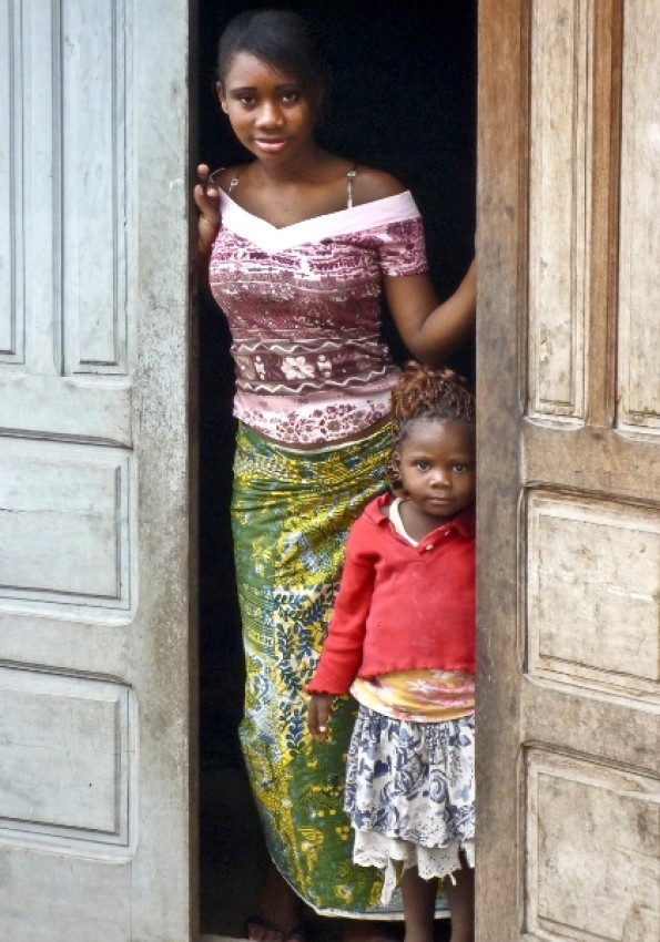 На пороге дома. В такую ткань, как на девушке, очень удобно заворачиваться: шить ничего не надо, и одета за секунду.