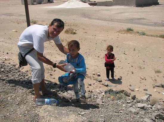 Арабская девочка тащит бутылку с холодной водой - ее родители увидели, что путешественники удаляются в сторону пустыни. "Арабы - очень отзывчивый народ", - говорит Алексей