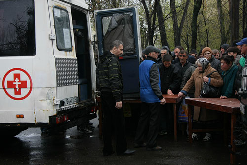 На вид большинство этих людей вполне приличны и опрятны. Но если приглядеться, то видно — не все в порядке. Например у женщины в коричневом пальто, она стоит в центре, в такую погоду на ногах...сандалии! Она живет на вокзале. Подробнее рассказвать о себе она отказалась.