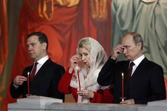 Russian President Vladimir Putin (R), Prime Minister Dmitry Medvedev (L) and his wife Svetlana (C) attend an Orthodox Easter service conducted by the Patriarch of Moscow and All Russia Kirill in the Christ the Saviour Cathedral in Moscow May 5, 2013. Photo: Reuters