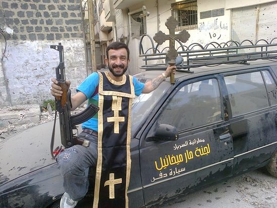 Syrian insurgent with "trophies"--a cross and epitrachelion from a desecrated church.