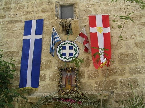 The flags of Greece and of the Guardians of the Holy Sepulchre, hanging above the monastery entrance.
