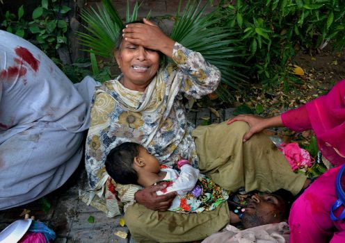 A Pakistani woman mourns as she holds the lifeless body of her granddaughter, a victim of a suicide attack on a church in Peshawar, Pakistan, Sunday, Sept. 22, 2013. Photo: Mohammad Sajjad