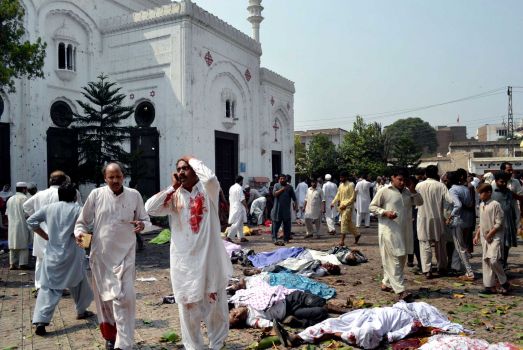 People gather next to victims of a suicide attack on a church in Peshawar. Photo: Mohammad Sajjad