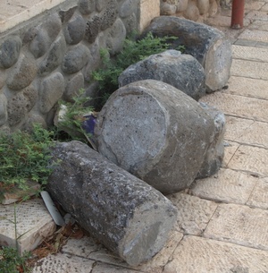 Roman column fragments, along with the top of a rotary quern (for grinding), lying on the side of a road in the modern-day town of Migdal. Photo: Dr. Ken Dark.