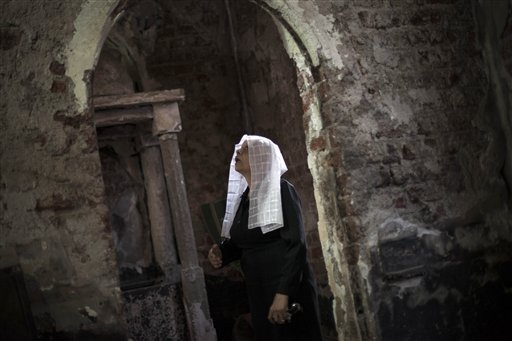 An Egyptian Coptic woman prays at a church burnt by radical Islamists on Aug. 14 in the town of Abanoub