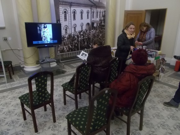 Посетители выставки смотрят фильм о событиях 20-х годов.