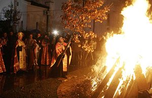 An Orthodox priest places the badnjak on the fire during Christmas Eve celebration at the Cathedral of Saint Sava in Belgrade.