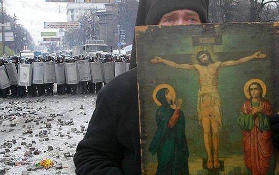 A monk with an icon stands between the demonstrators and the “Berkut”