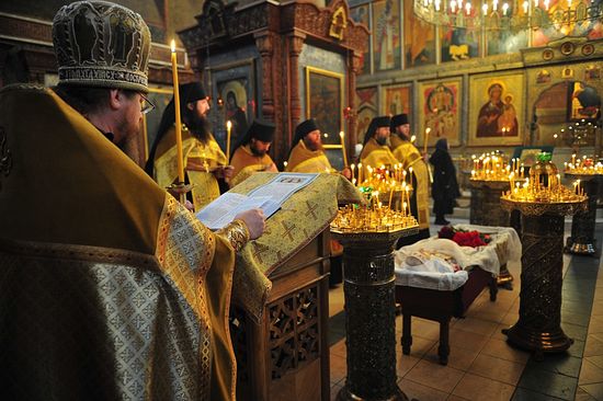 Архимандрит Тихон читает разрешительную молитву над усопшей Евгенией Матвеевной Грикой. Фото: Православие.Ru