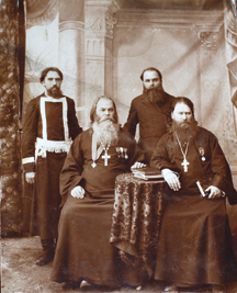 Николай Кутлинский (стоит слева) и отец Ксенофонт Крюков (сидит справа). Фотография начала XX века