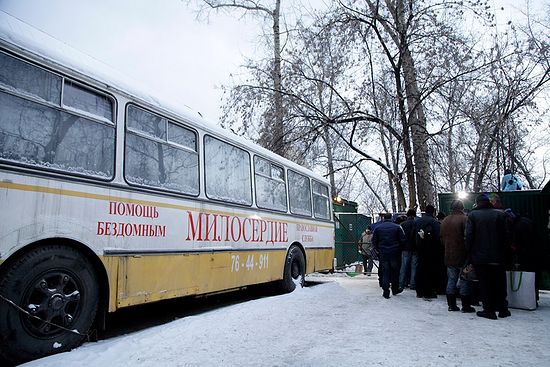 Бездомные ожидают своей очереди на вход на территорию социального пункта. Слева – автобус православной службы «Милосердие»