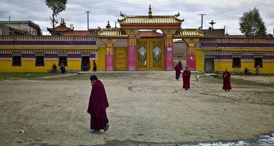 Buddhist monks outside one of the entrances to the Kirti monastary in the town of Aba in China’s Sichuan province. Communist-approved versions of Buddhism, Taoism, Islam, Catholicism and Protestantism are the only religions allowed in China. Photograph: STR/AFP/Getty Images