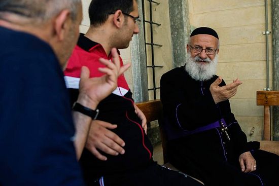 Father Yousif Al Banna talking with other Christian refugees in Saint Matthew monastery near Al Faf, Iraq on Wednesday, June 18, 2014. Father Yousif said “I fear our churches will be burned and possibly no Christians will return.” 