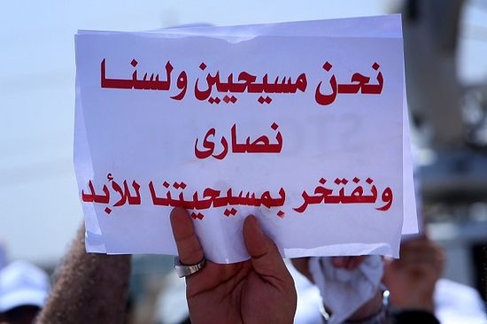 Iraqis holds up a banner which reads in Arabic 'We are Christians and not Nazarethans, and we are proud of our religion', during a demonstration on July 24, 2014, against the threat imposed by ISIS. (Image: SAFIN HAMED/AFP/Getty Images)