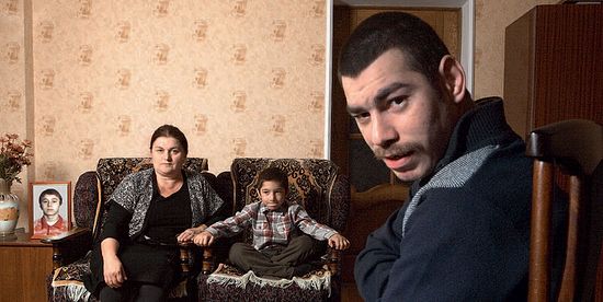 Фатима Малкиева и ее сыновья. Справа — портрет погибшего Арсена, на кресле — Давид, справа на стуле — Руслан