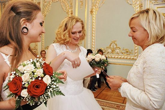Однополая пара получает свидетельство о браке в петербургском загсе. Справа - человек с документами мужчины