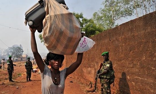 Rwandan peacekeeping troops look on as a woman in Bangui, CAR, flees after an attack by anti-balaka militia. Photograph: Issouf Sanogo/AFP/Getty Images