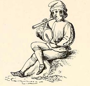 Rustic Christmas minstrel with pipe and tabor.