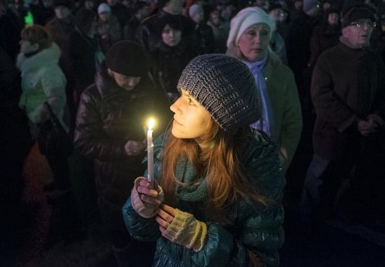 A pro-European integration supporter holds a candle as she celebrates Orthodox Christmas in Independence Square in Kiev, Jan. 6, 2014. Reuters