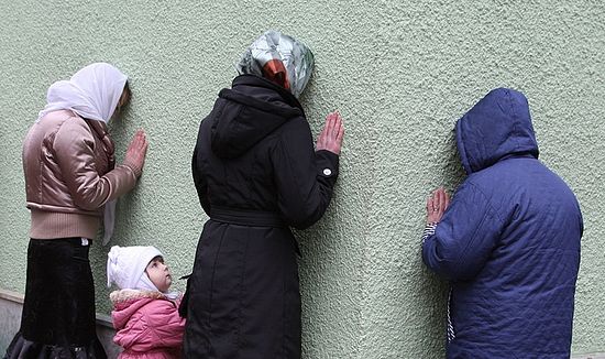Женщины молятся у стен часовни блж. Ксении Петербургской на Смоленском кладбище. Фото: Юрий Костыгов