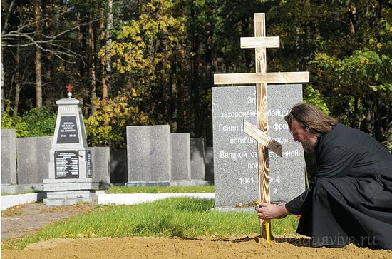 Протоиерей Валериан Жиряков зажигает свечи на месте захоронения 268 солдат и офицеров в д. Озерки