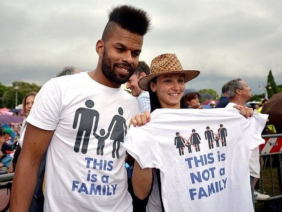 Протестующие в Риме. На футболке у парня написано: "Это семья". Девушка держит фубтолку с надписью "Это не семья"