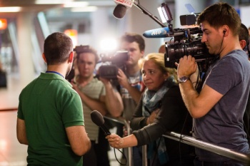 A photo taken on July 10, 2015 shows a young Syrian engineer (L) speaking with journalists at Warsaw Airport after more than 150 Christian refugees from Syria arrived in Poland to find asylum from the war and ISIS fighters. 