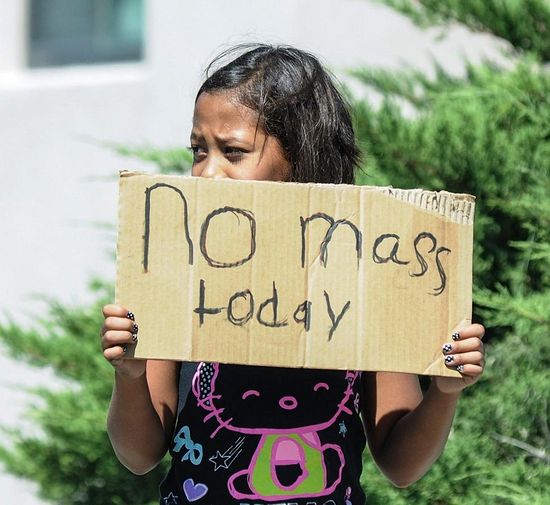 Девочка стоит с плакатом "Мессы не будет". Фото: AP
