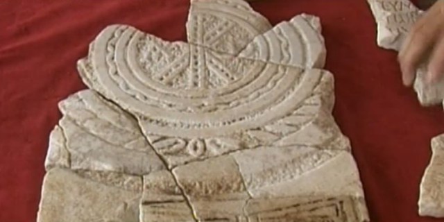 The fragments making up the 6th century AD marble slab with a christogram and a donor's inscription below it have been discovered by the archaeologists excavating the Bishop's Basilica of Ancient Parthicopolis in Bulgaria's Sandanski over a period of 25 years. Photo: TV grab from BNT