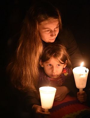 A woman holds her daughter during a vigil in Roseburg, Oregon for ten people killed and seven others wounded in a shooting at a community college.
