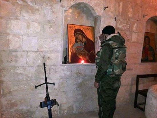 A soldier of the Syrian army prays before the Most Holy Theotokos before battle.