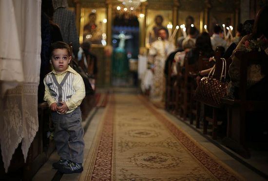 A Palestinian boy attends Orthodox Christian Palm Sunday Mass with his family at the Saint Porfirios church in Gaza City, April 13, 2014.PHOTO: SUHAIB SALEM/REUTERS