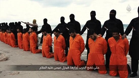 Men in orange jumpsuits purported to be Egyptian Christians held captive by the Islamic State group kneel in front of armed men along a beach said to be near Tripoli, Libya, in this still image from an undated video made available on social media, Feb. 15, 2015.PHOTO: SOCIAL MEDIA VIA REUTERS TV