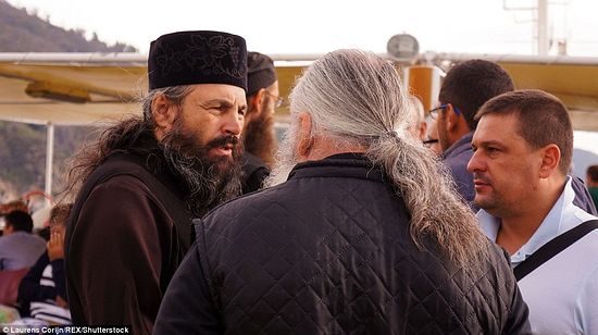 Pilgrims gather round the monks on a ferry that departs for Holy Mount Athos, using an opportunity to communicate with the those living the monastic life.