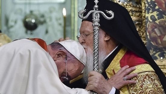Ecumenical Patriarch Bartholomew I, right, kisses Pope Francis' head.