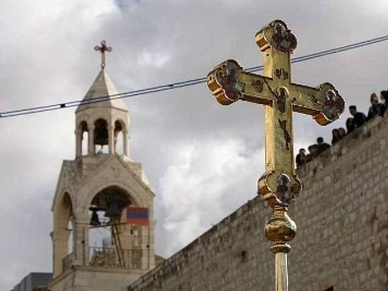 A crucifix is held up in front of the Church of the Nativity during the Orthodox Christmas procession in the West Bank town of Bethlehem January 6, 2011. PHOTO: REUTERS