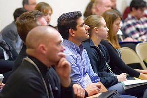 Attendees listen attentively before offering feedback and questions.