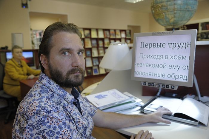 Инвалид по зрению Илья Гаврилов работает с электронной лупой, позволяющей читать книги и журналы с огромным (в сотни раз) увеличением