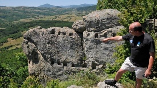 Archaeologist Zdravko Dimitrov on the site near Bulgaria’s Angel Voyvoda, with the rock shrine niches visible in the background. Photo: BGNES
